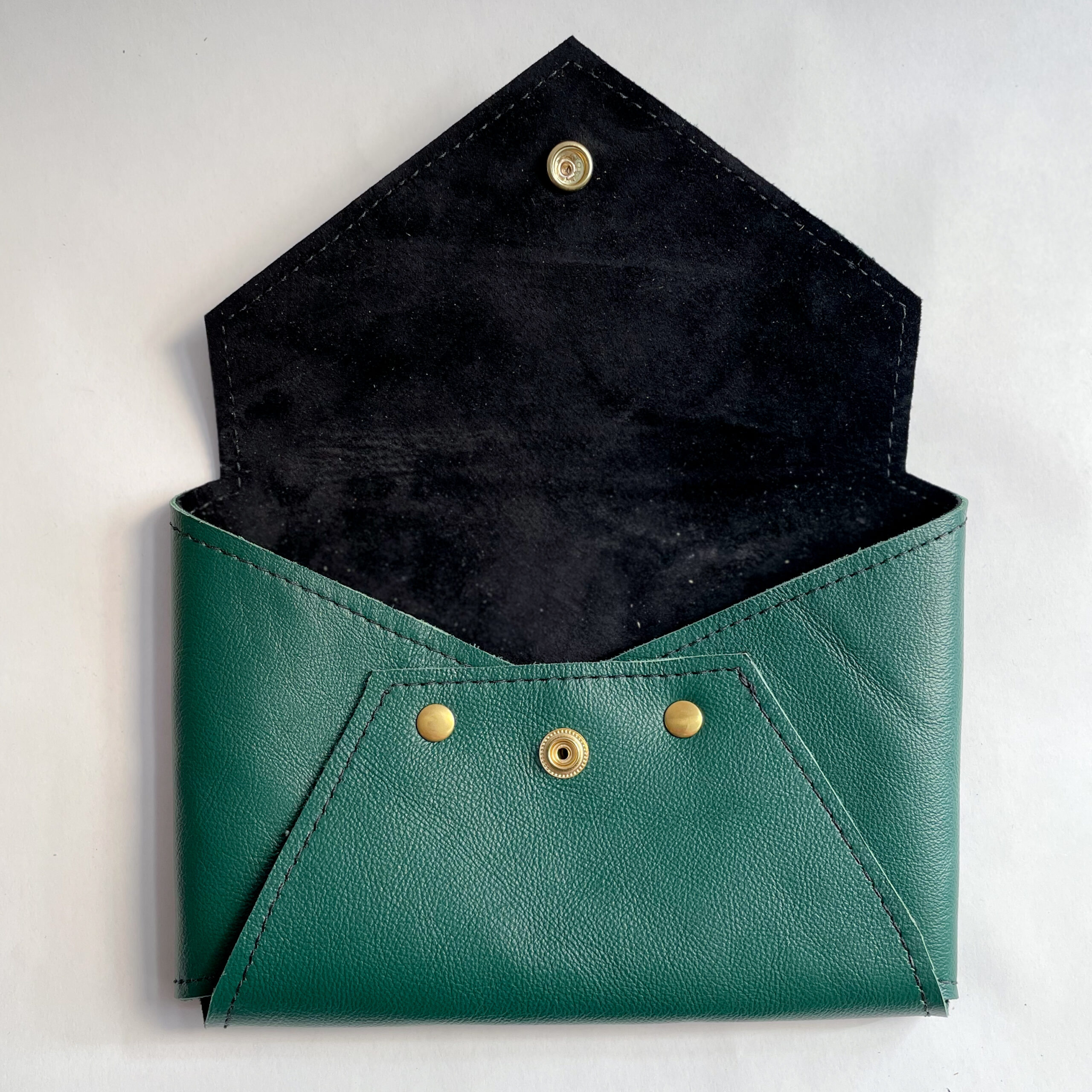 Green Envelope Clutch sitting open to reveal black lining