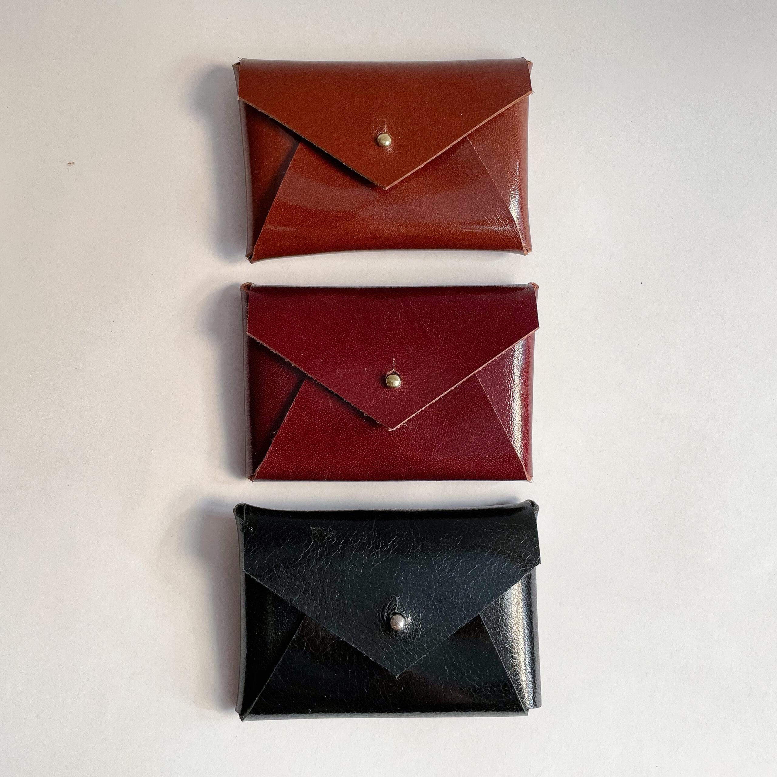 Three leather card cases laying on their back